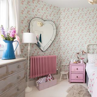 bedroom with pink floral printed wall with white bed
