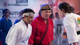 Ralph Macchio as Daniel LaRusso and William Zabka as Johnny Lawrence bow to Mary Mouser as Sam LaRusso in Cobra Kai 