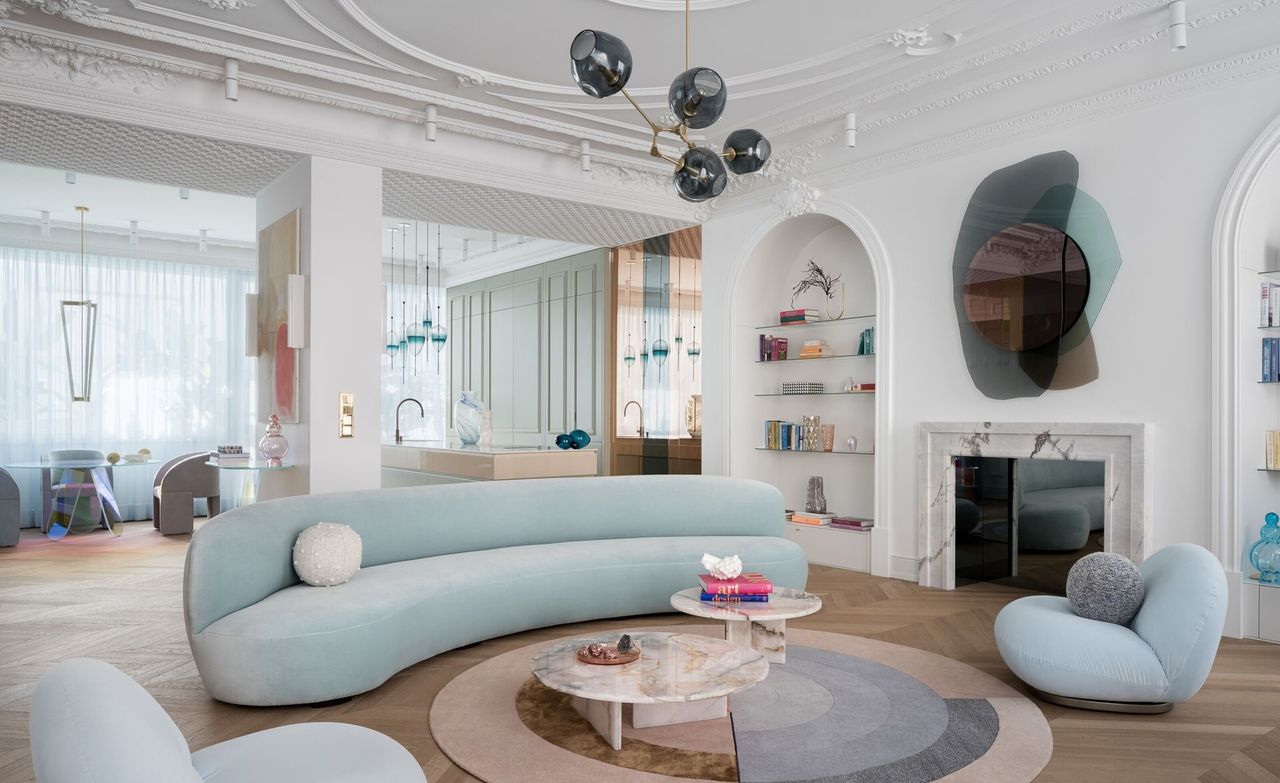 A living room with white walls and pastel colored decor