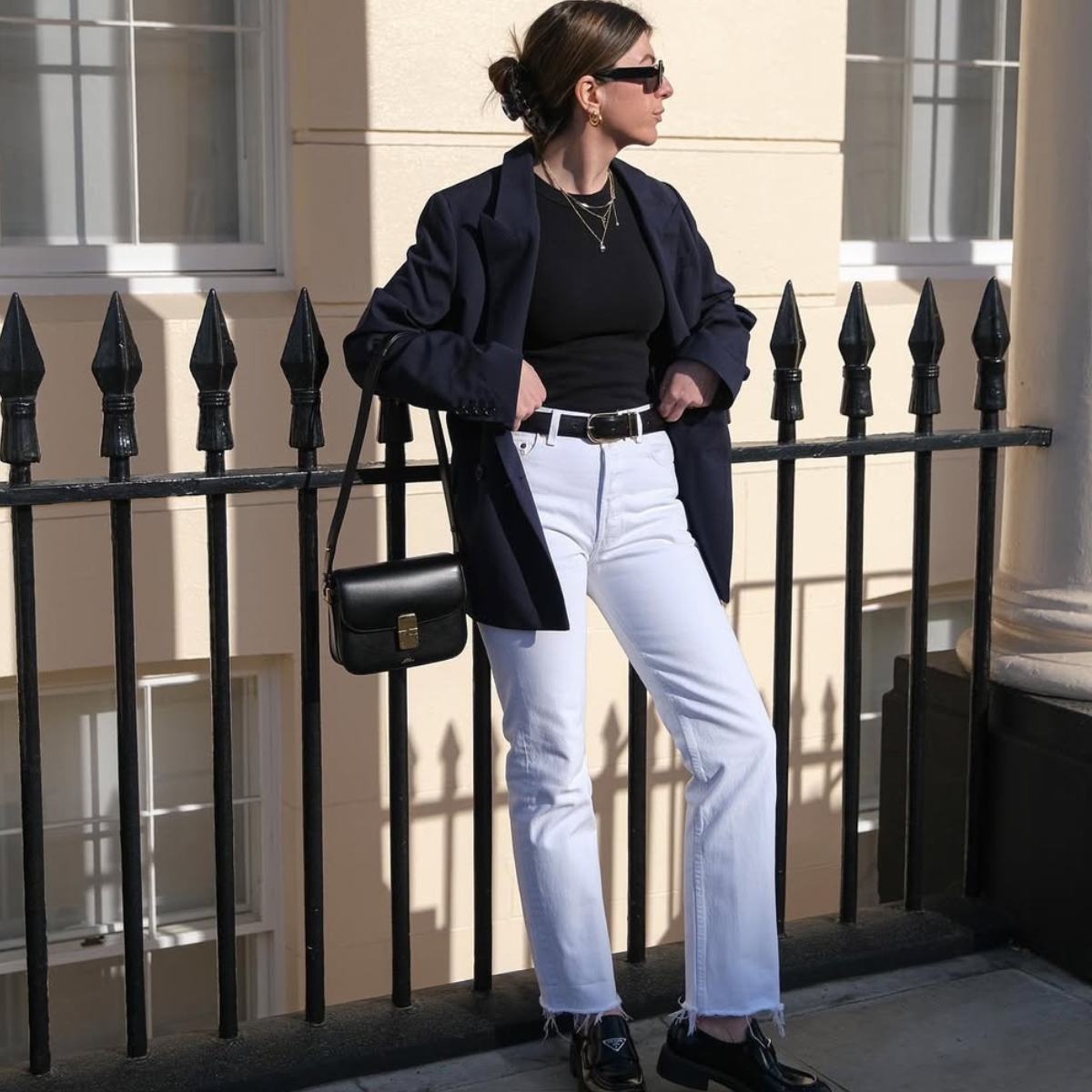 A woman wears a blazer, black t-shirt and jeans