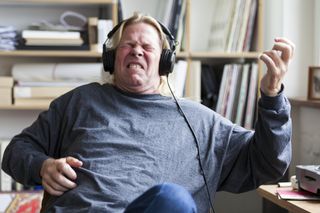 A man in headphones rocks out to music.
