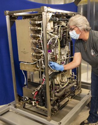 A technician checks out the Four Bed CO2 Scrubber at NASA’s Marshall Space Flight Center in Huntsville, Alabama.