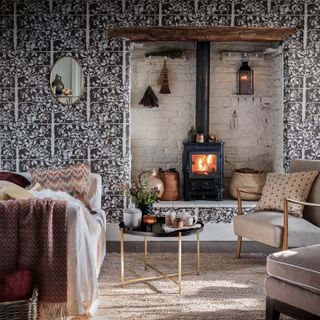 Rustic living room with a burning fireplace and patterend wallpaper