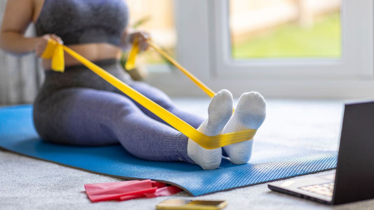 Woman trains indoors with a resistance band