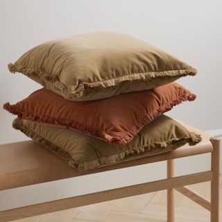 three cushions in rust and brown tones