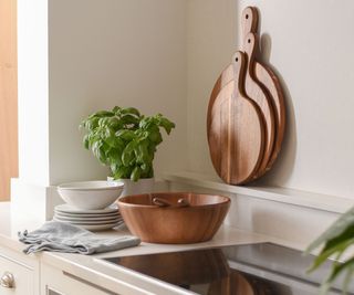 A wooden acacia bowl and chopping boards in a kitchen