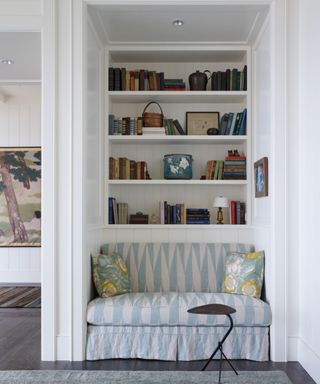 built-in reading nook with blue and white upholstered seat and bookcases behind