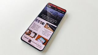 OnePlus 10T review: t3 website open on a phone screen lying on a white table