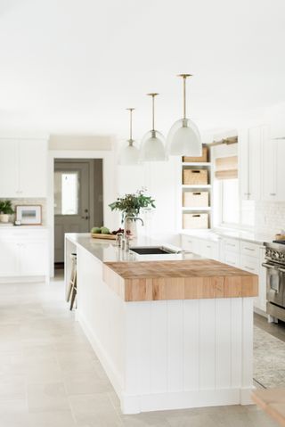 white kitchen island with integrated wooden and ceramic work top