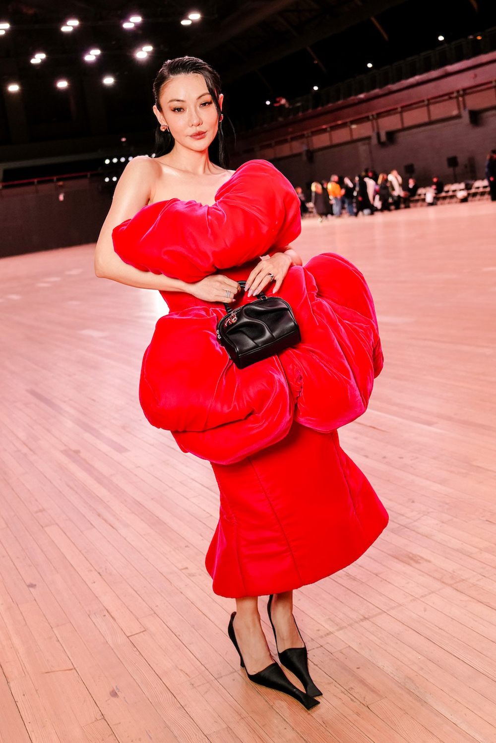 Jessica Wang posing in a red voluminous dress and black heels with exaggerated toe length during the Marc Jacobs spring 2026 fashion show during NYFW.