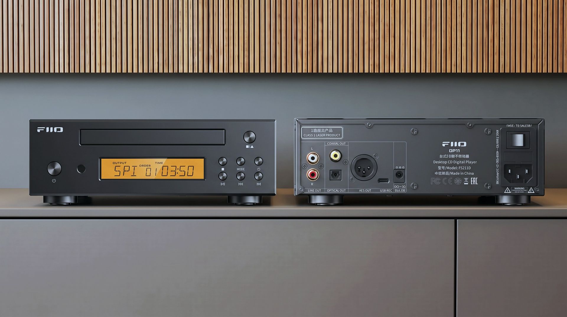 FiiO DP11 in black on a hi-fi table, with wooden panelling in the background