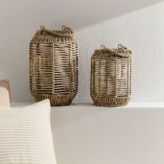 H&M rustic candle holder on a ledge next to a cushion