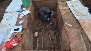 A researcher examines the double burial tomb.