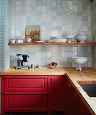 Red cabinets, wooden countertop, white china
