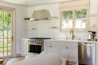 A small kitchen with white cabinetry and a stainless steel range