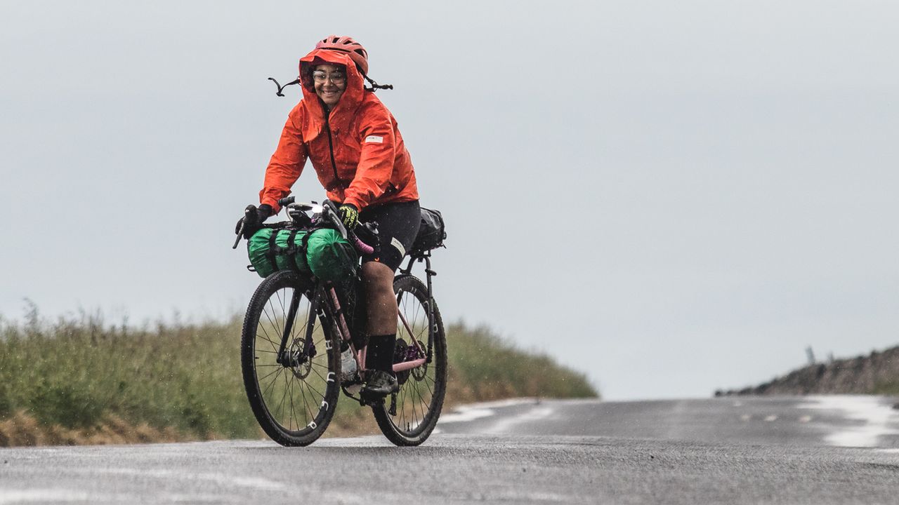 A cyclists riding on the road in the rain