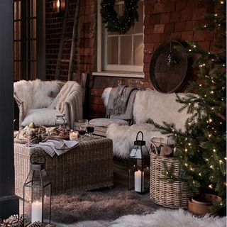 Outdoor Christmas lighting ideas with outdoor sofa and armchairs and fur throws
