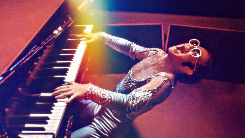 Elton John leans back to hammer the piano keys wearing trademark sparkly glasses and blue jumpsuit in new Disney Plus documentary Elton John: Never Too Late 