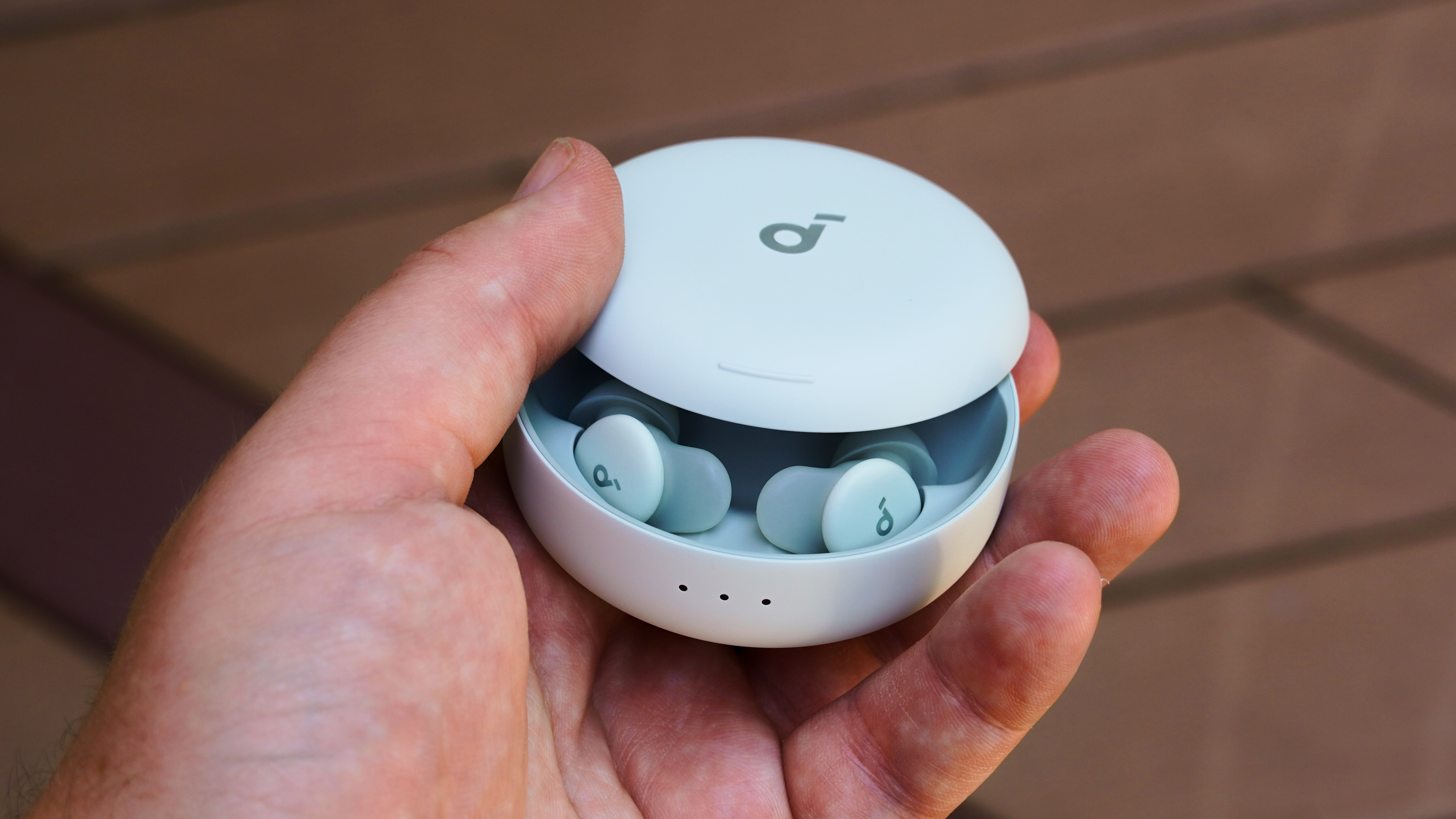 The Anker Soundcore Sleep A30 earbuds with the case half-opened in the hand. 