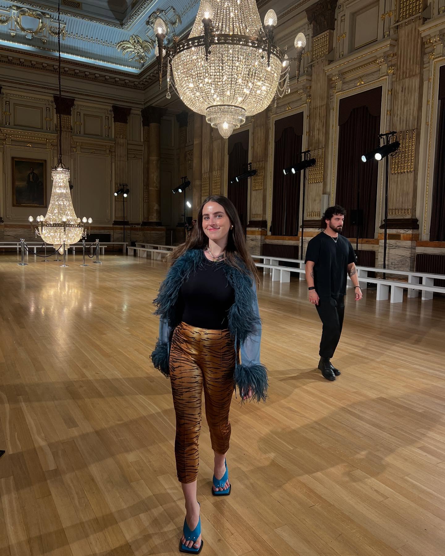 An image of @avahgilchrist showcasing how to wear pedal pushers in leopard-print pants, a feathered top and blue wedges.