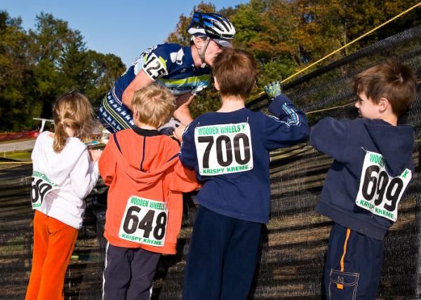 A group of young racers watch to see how an elite rider does it.