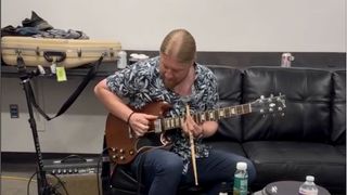 Derek Trucks plays slide on his Dickey Betts SG using a drumstick