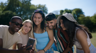 A photo of a group of people using a Tecno smartphone