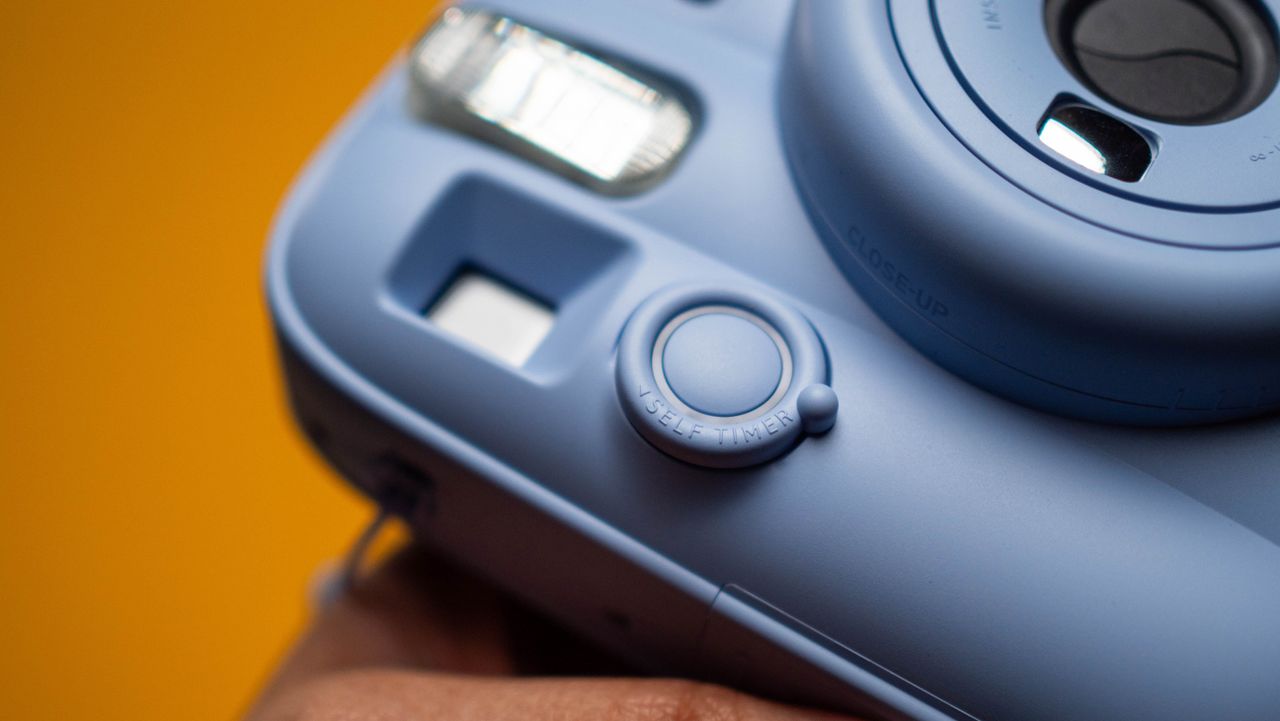 Fujifilm Instax Mini 13 instant camera against a yellow colored sheet