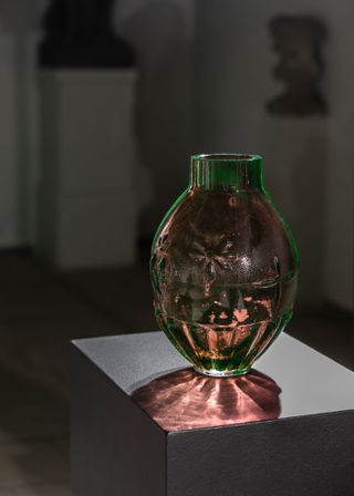 Glass blown vase in green and amber glass on metal block