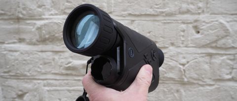 Bushnell Equinox Z2 6x50 Night Vision Monocular held in a hand against a white wall