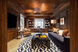 A cozy tv room with wood panelling