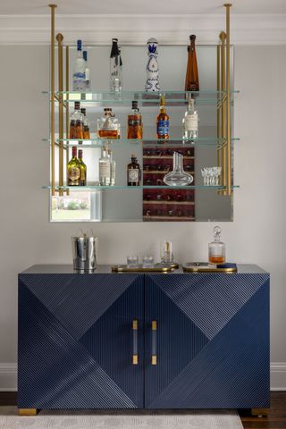 Blue bar cabinet in living rom in front of wall painted in Benjamin Moore's Calm.