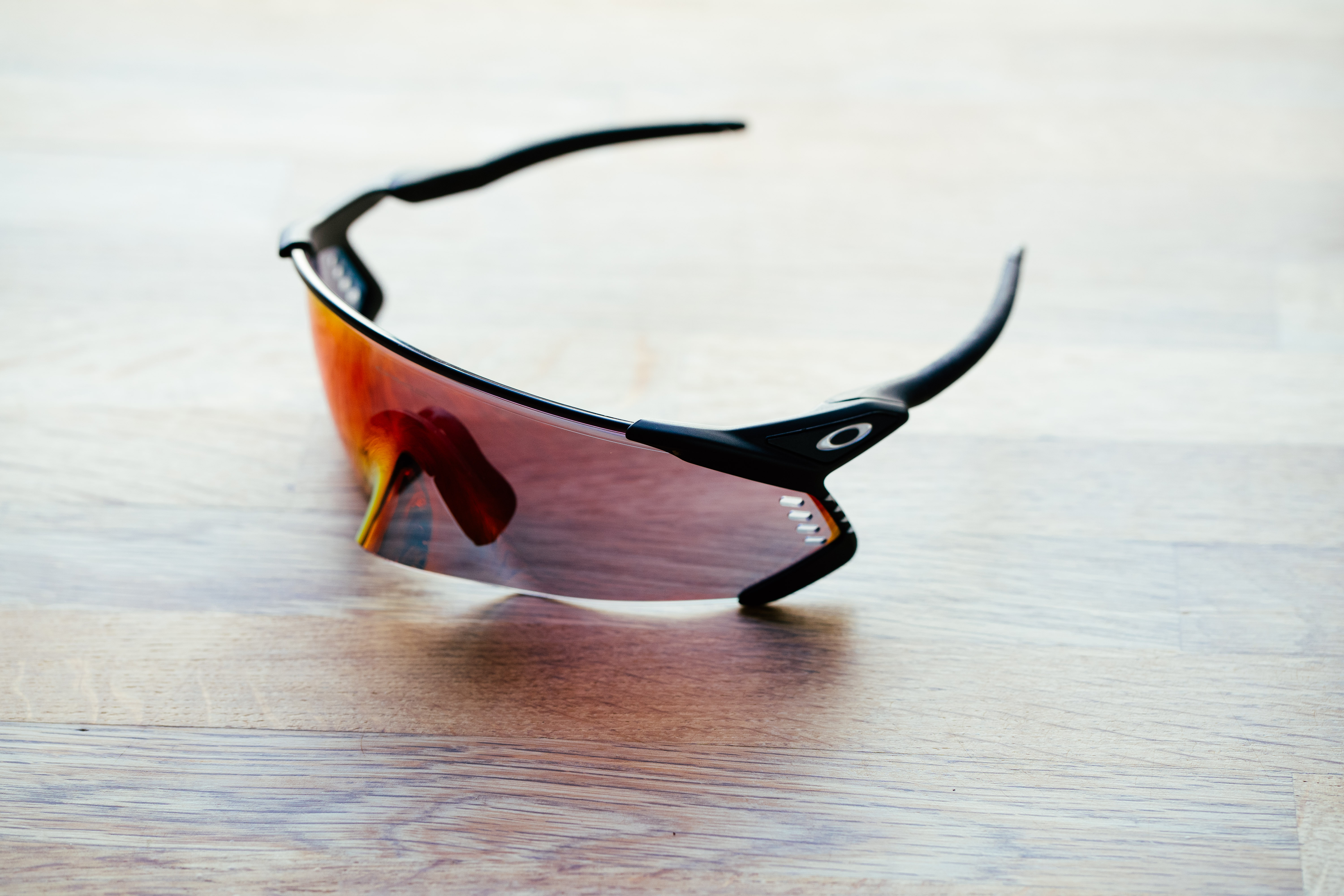 A set of large wraparound sports glasses on a wooden surface