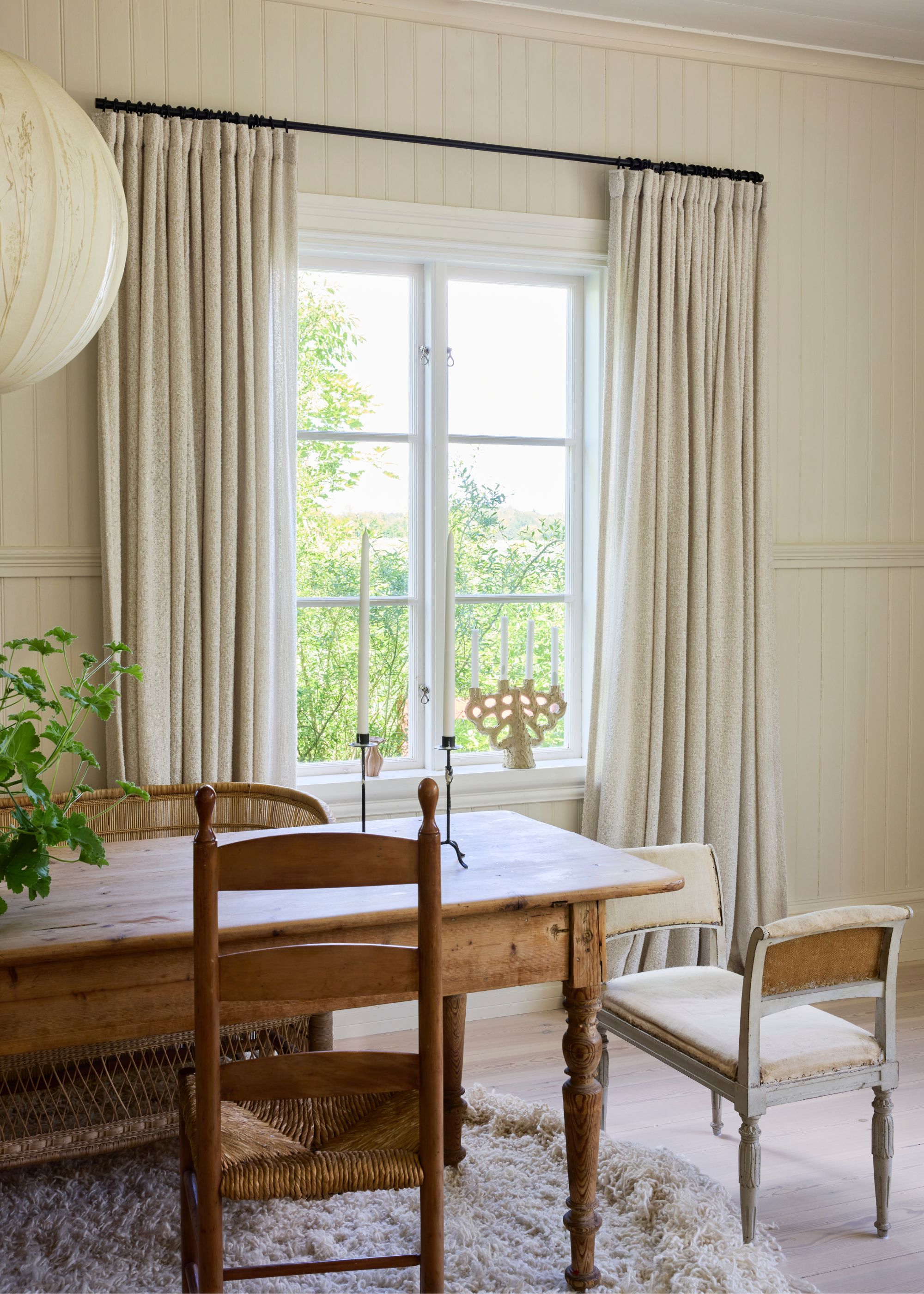 dining room with neutral boucle curtains, neutral walls and wooden dining table and chairs