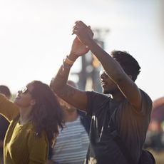 friends with arms in the air at festival concert