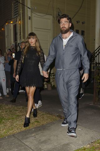 Taylor Swift wears a black lace dress with black laced boots and holds hands with boyfriend Travis Kelce ahead of the 2025 Super Bowl in New Orleans