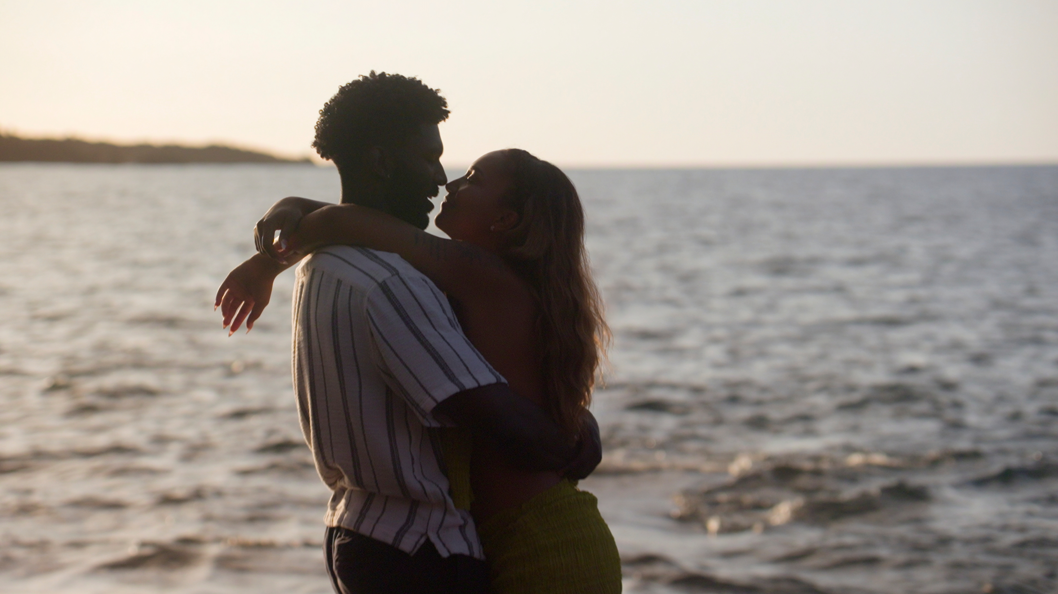 Xzavier Odom and Sydney McGregor embrace and smile at each other on the beach at sunset in temptation island season 2