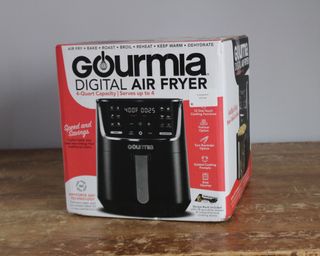 Gourmia 4-quart digital air fryer in box on distressed wooden table