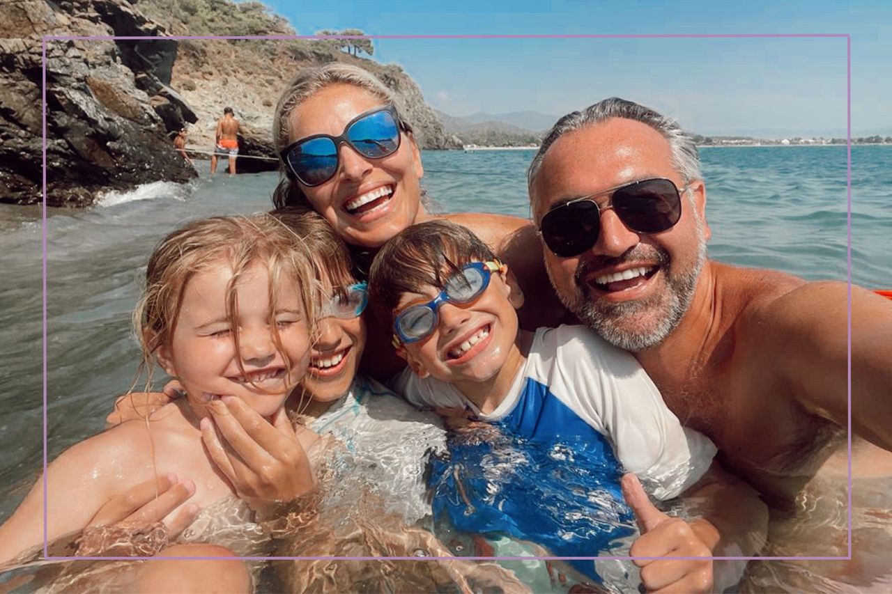 Family at the beach all smiling at camera