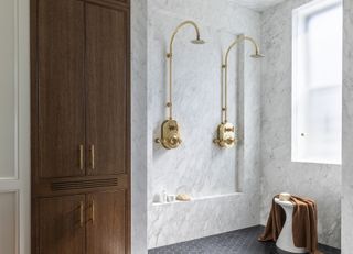 A shower room with double showerheads in brass