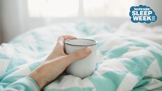 Person in bed drinking coffee from a mug