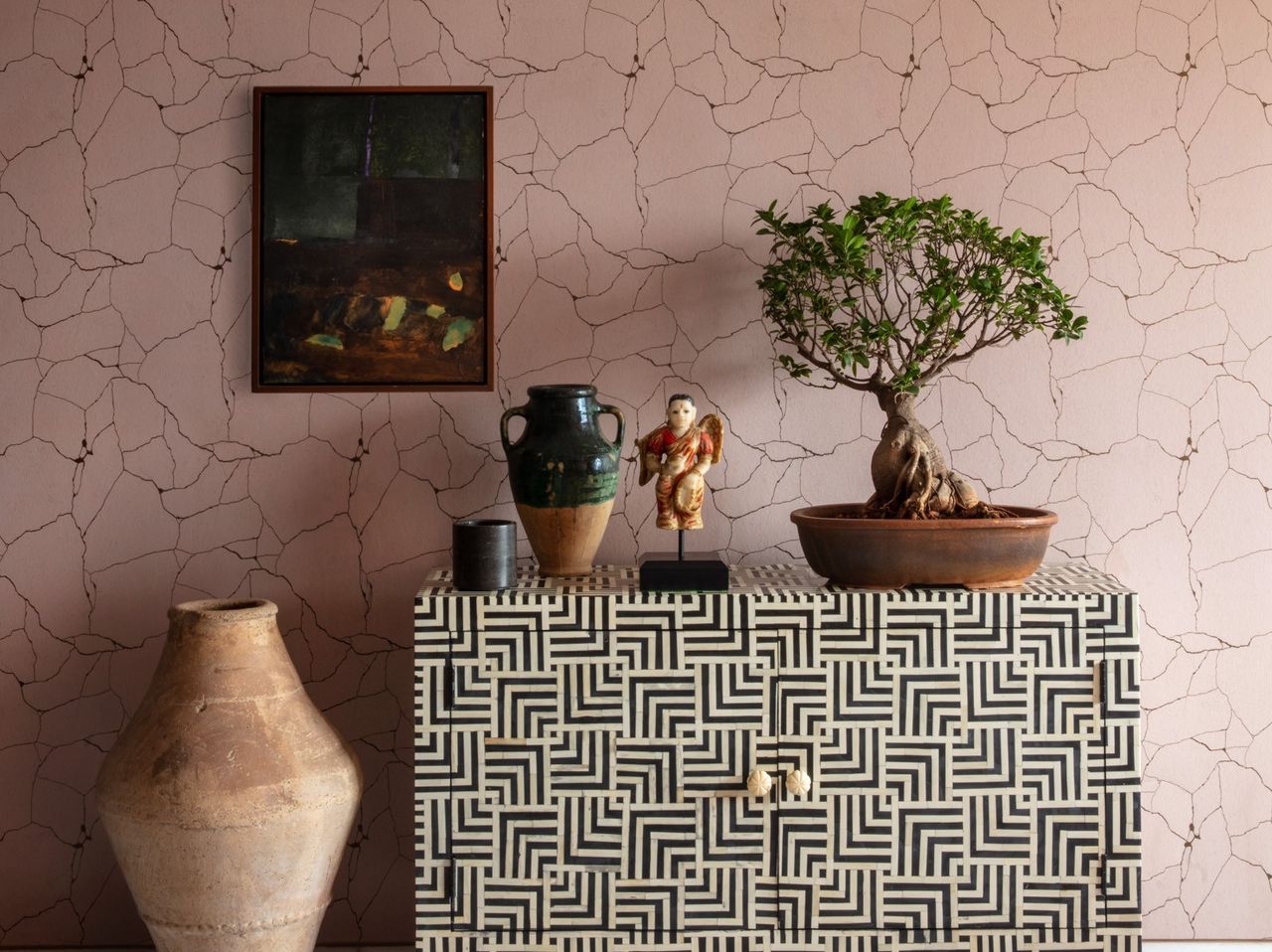 An entrance space with a bonsai tree kept atop a console