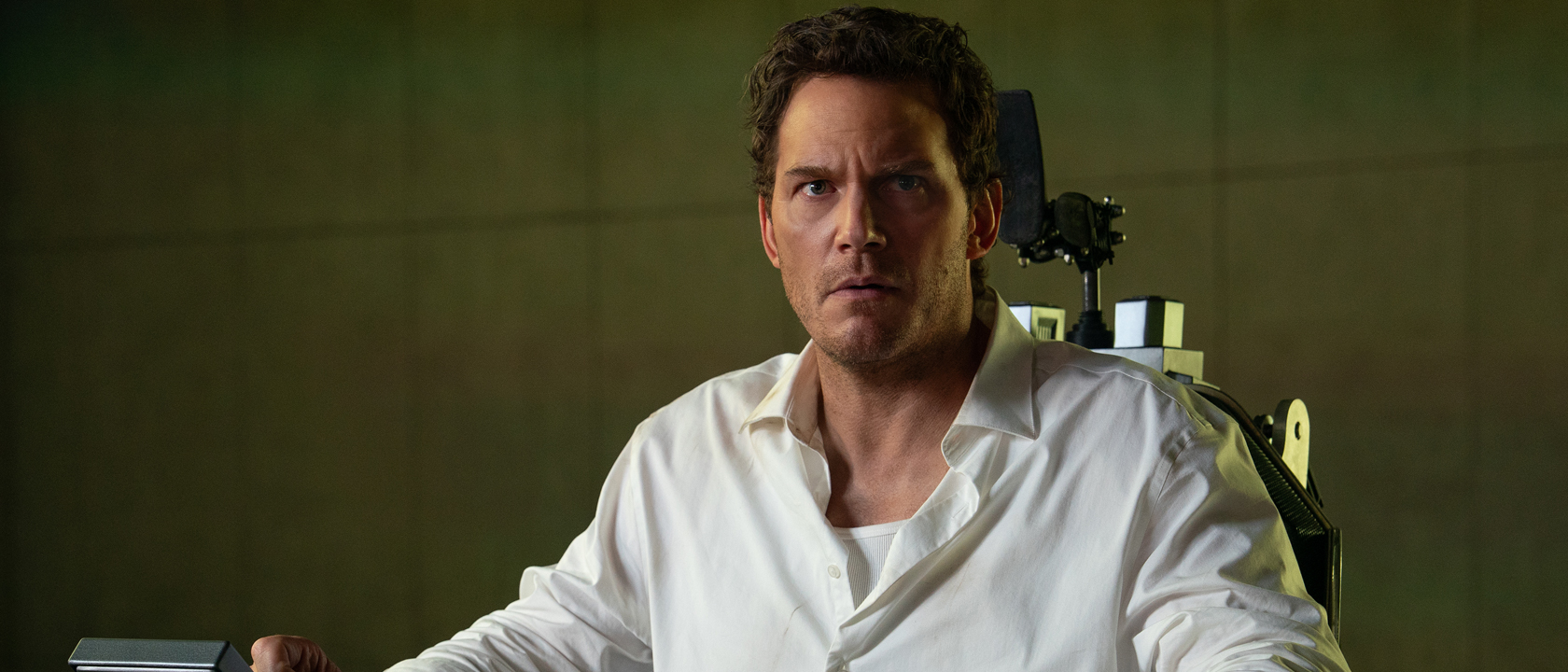 Chris Pratt as Chris Raven sitting in a chair in Mercy 