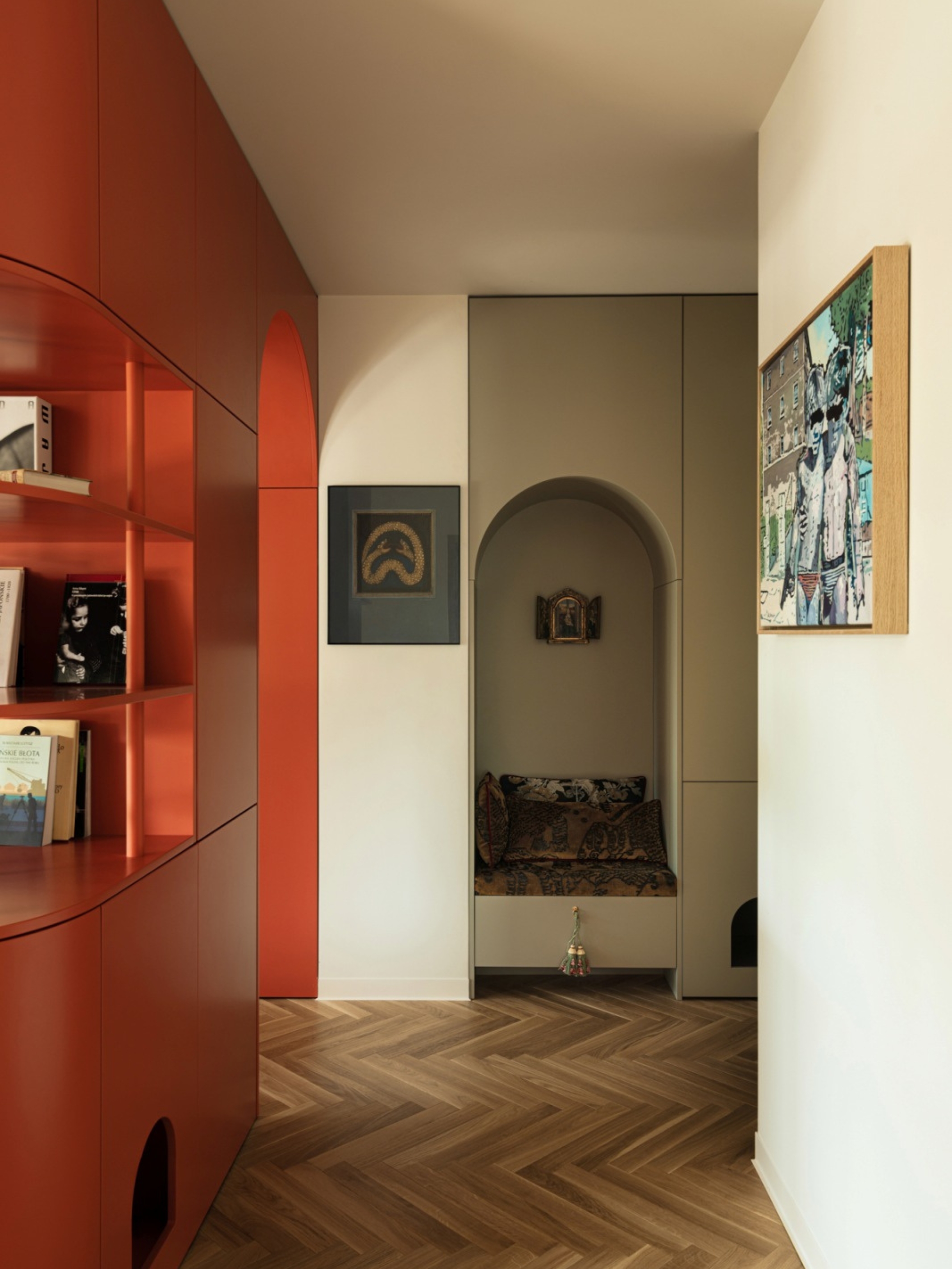 an apartment entryway with an orange red built-in across the space