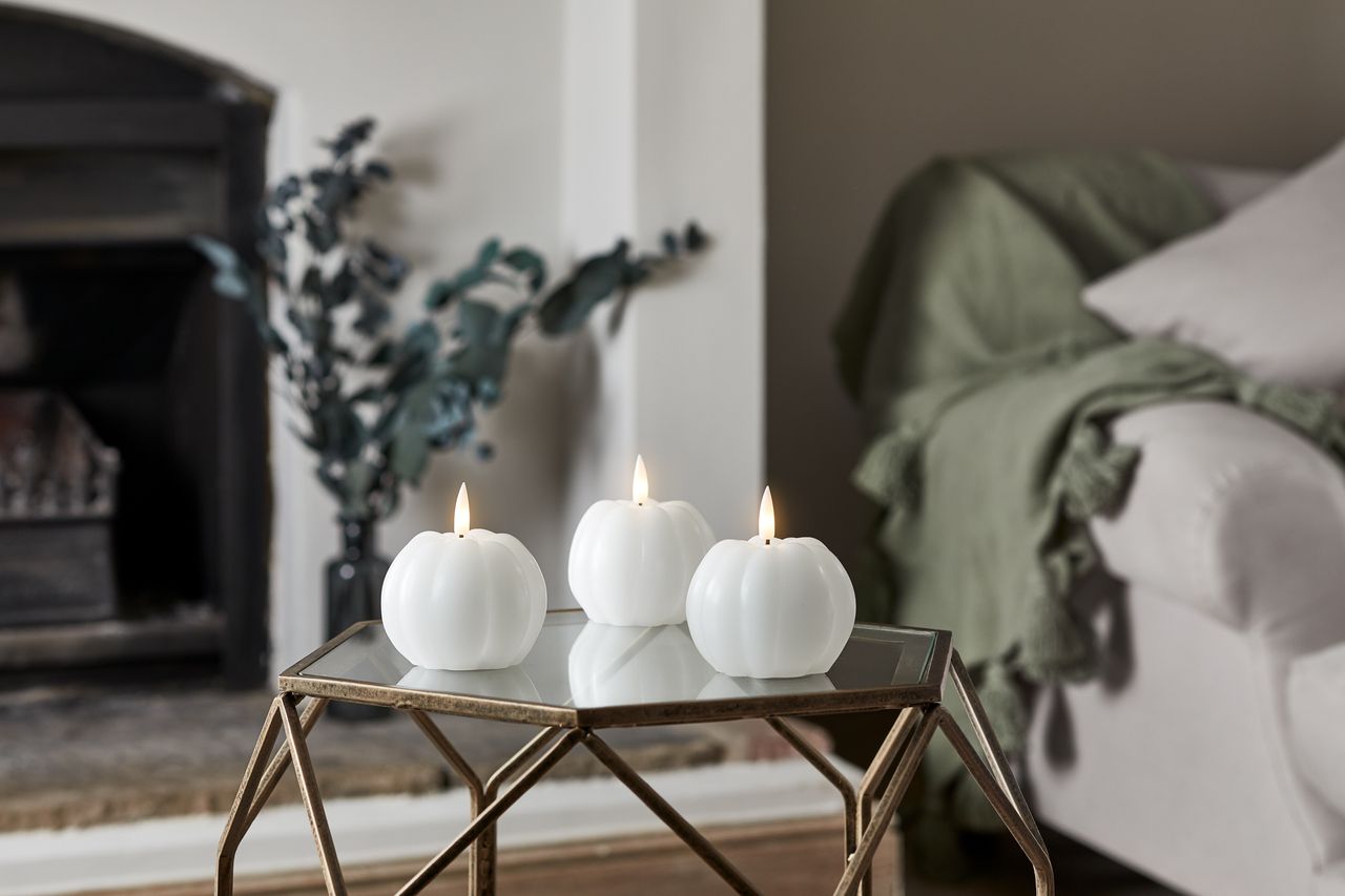 A coffee table with pumpkin candles