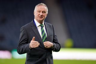 Northern Ireland manager Michael O'Neill, wearing a suit, gestures with his right hand, March 2024