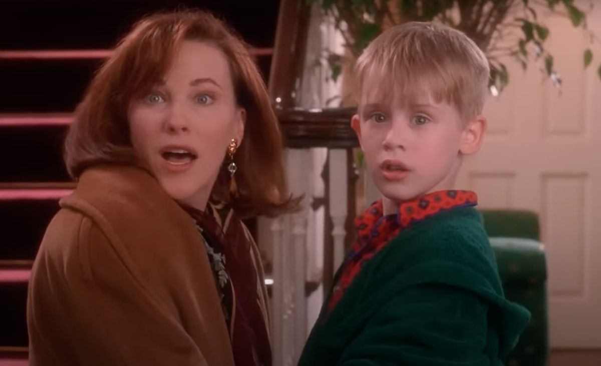 Catherine O&#039;Hara and Macaulay Culkin in Home Alone looking surprised at the door opening after reuniting.