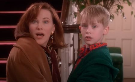 Catherine O'Hara and Macaulay Culkin in Home Alone looking surprised at the door opening after reuniting.