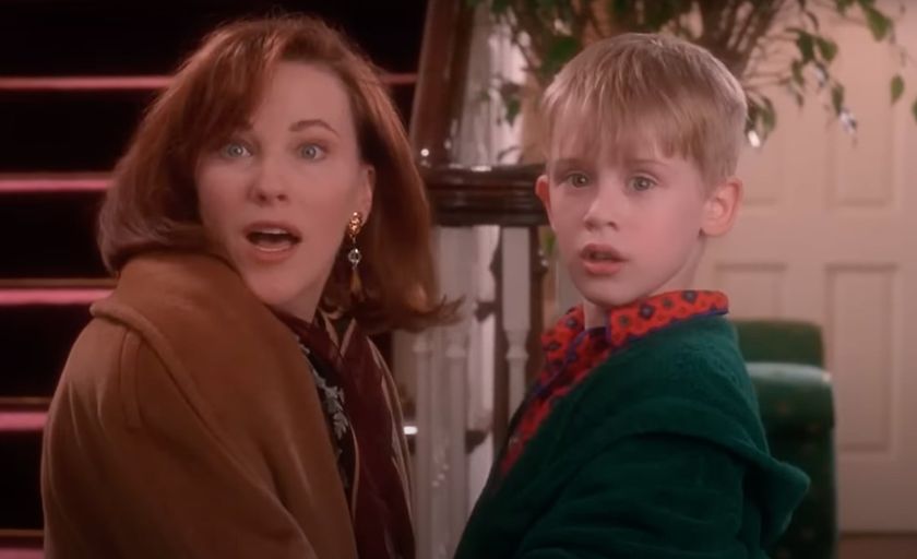 Catherine O&#039;Hara and Macaulay Culkin in Home Alone looking surprised at the door opening after reuniting.