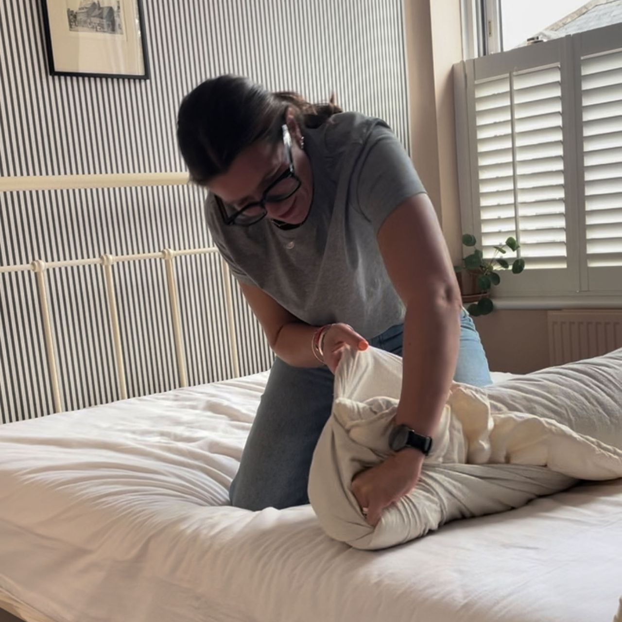 A woman putting a duvet cover onto a duvet using the 'burrito' method